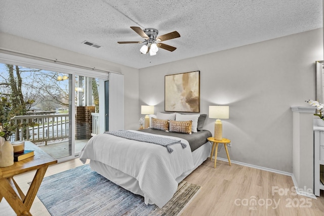 bedroom featuring ceiling fan, access to exterior, a textured ceiling, and light wood-type flooring