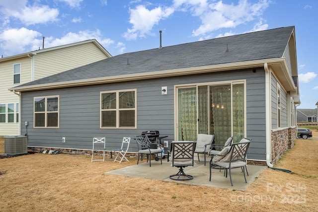 rear view of house with central AC unit, a lawn, and a patio