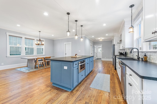 kitchen featuring white cabinetry, decorative light fixtures, a center island, and blue cabinets