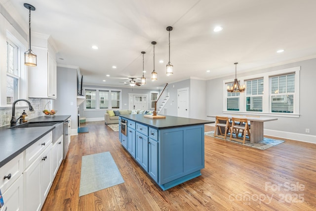 kitchen with blue cabinetry, white cabinetry, and hanging light fixtures