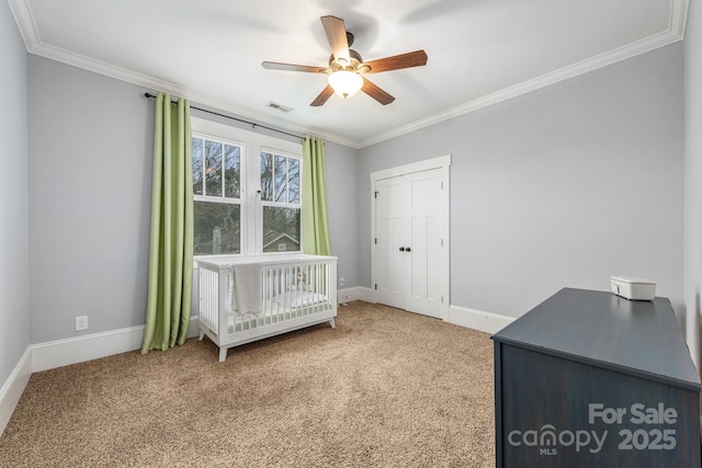 unfurnished bedroom with ceiling fan, ornamental molding, carpet flooring, and a closet