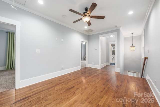 empty room featuring crown molding, wood-type flooring, and ceiling fan