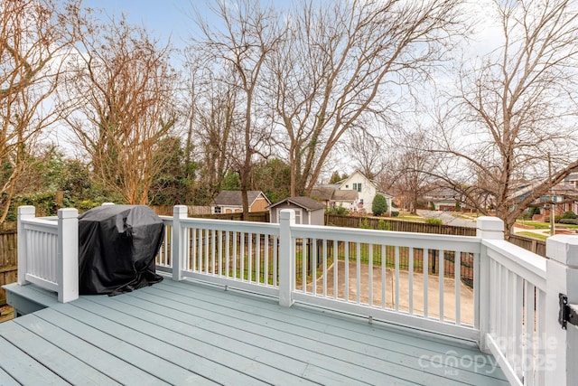 deck with grilling area and a shed