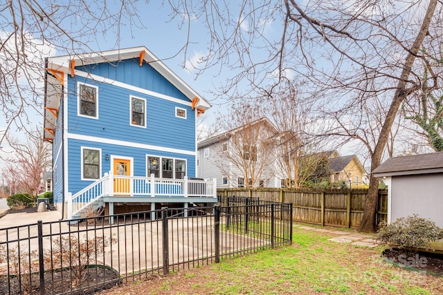 back of house featuring a deck and a lawn