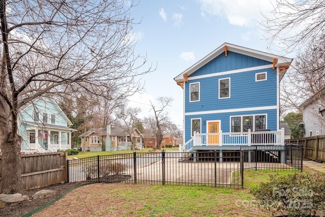 rear view of house with a wooden deck and a lawn