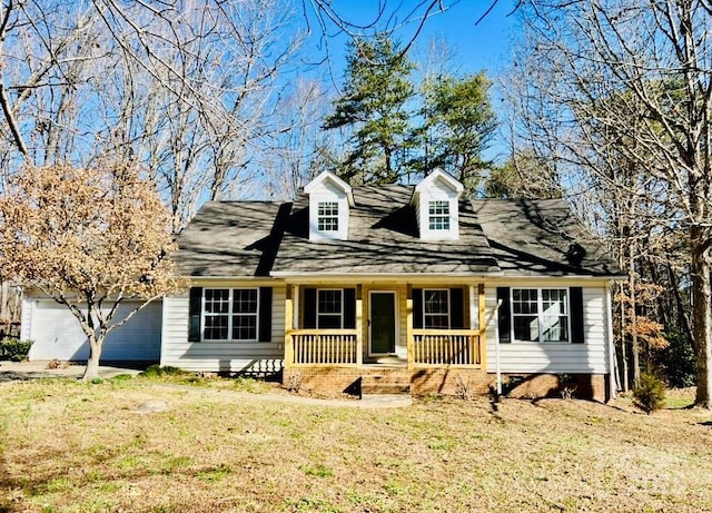 cape cod house featuring covered porch, a garage, and a front lawn