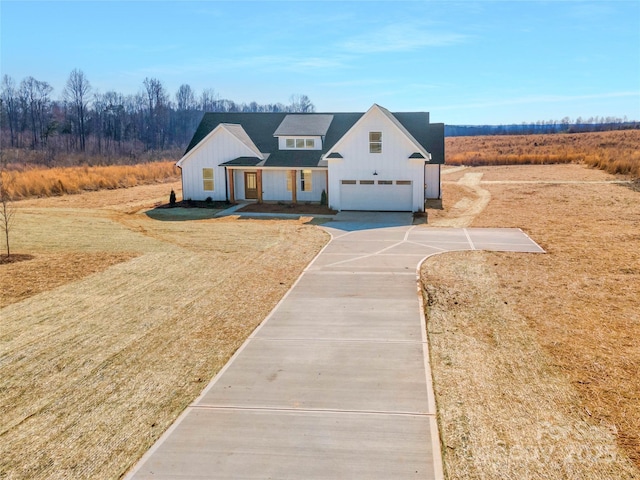 modern farmhouse style home with a garage, board and batten siding, concrete driveway, and a front yard