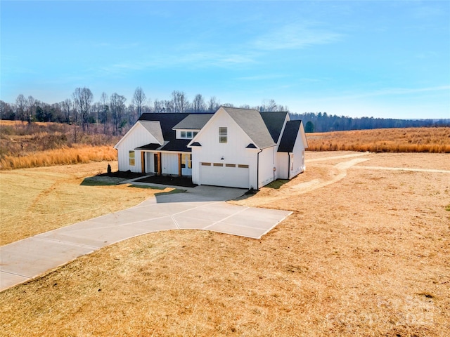 modern inspired farmhouse with a garage, a front lawn, and concrete driveway