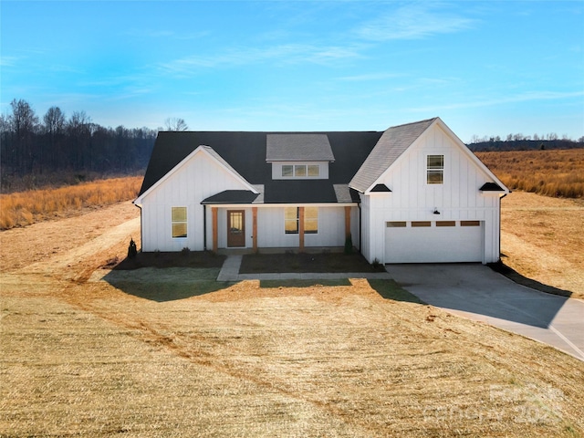 modern inspired farmhouse with a garage, concrete driveway, and board and batten siding