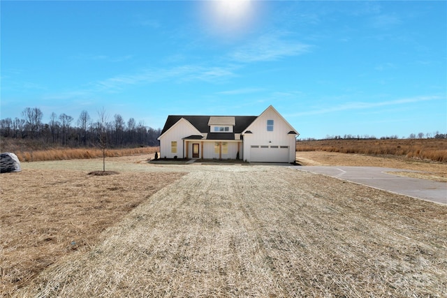 view of front of property with board and batten siding, a rural view, and driveway