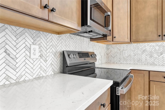 kitchen featuring light stone countertops, tasteful backsplash, stainless steel appliances, and brown cabinetry