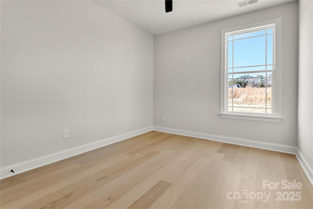 empty room featuring visible vents, ceiling fan, light wood-style flooring, and baseboards