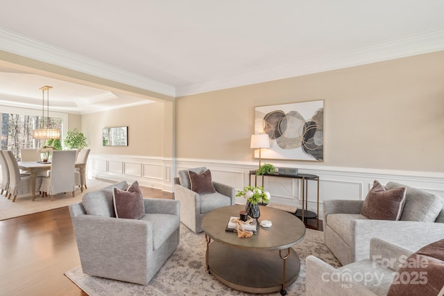 409 Running Horse Ln, Waxhaw, NC 28173 - living room featuring ornamental molding, wood finished floors, a wainscoted wall, and a chandelier