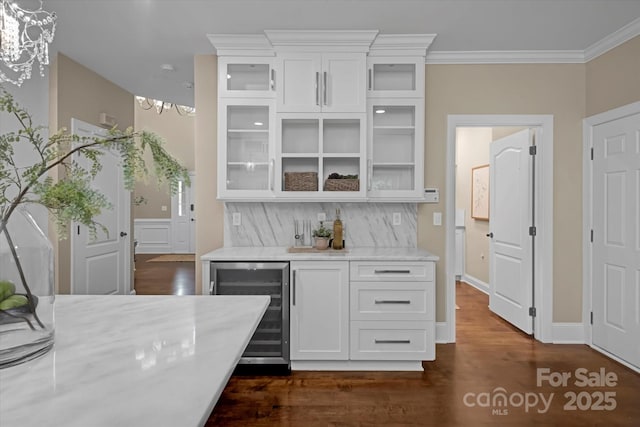 409 Running Horse Ln, Waxhaw, NC 28173 - kitchen with beverage cooler, a chandelier, white cabinetry, glass insert cabinets, and ornamental molding