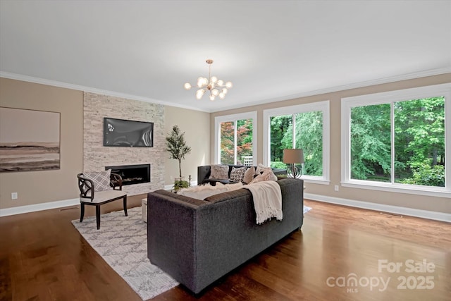 409 Running Horse Ln, Waxhaw, NC 28173 - living area featuring crown molding, wood finished floors, baseboards, a stone fireplace, and a chandelier