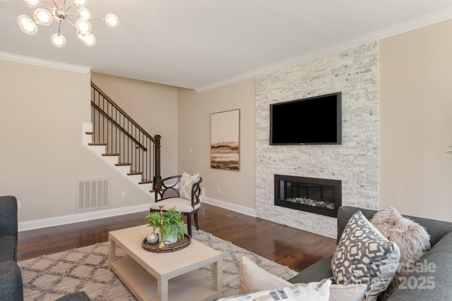 409 Running Horse Ln, Waxhaw, NC 28173 - living room with wood finished floors, a chandelier, a stone fireplace, crown molding, and stairway