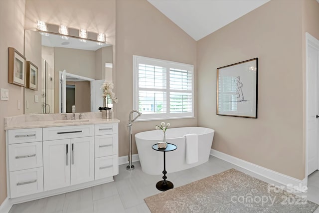 409 Running Horse Ln, Waxhaw, NC 28173 - bathroom with lofted ceiling, a soaking tub, baseboards, and vanity