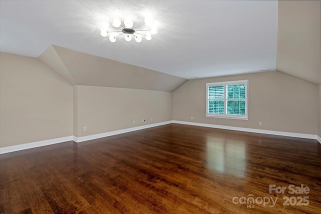 409 Running Horse Ln, Waxhaw, NC 28173 - additional living space with wood finished floors, vaulted ceiling, baseboards, and a chandelier