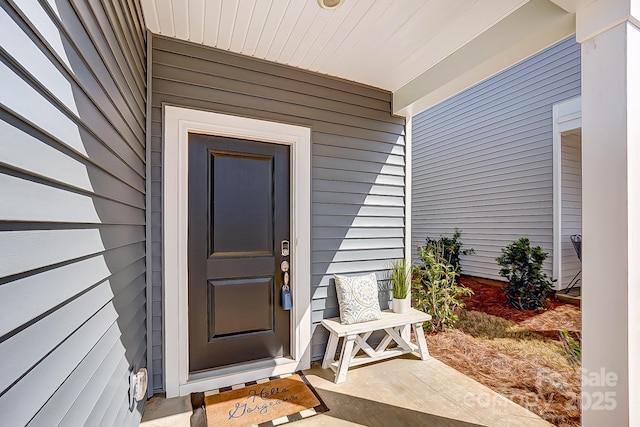 view of exterior entry featuring covered porch