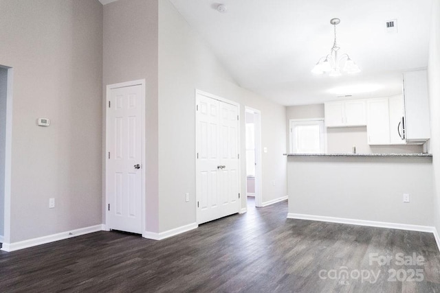 interior space featuring a notable chandelier, dark wood-style flooring, visible vents, and baseboards