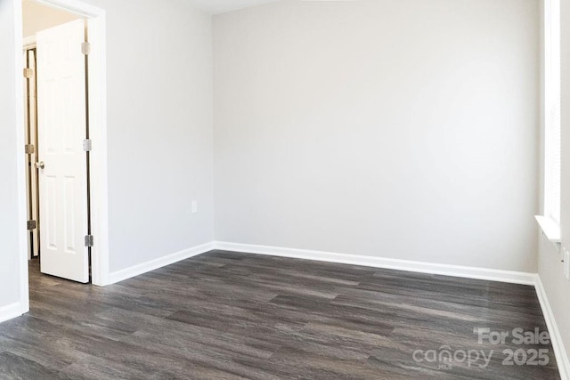 unfurnished room with dark wood-style floors and baseboards