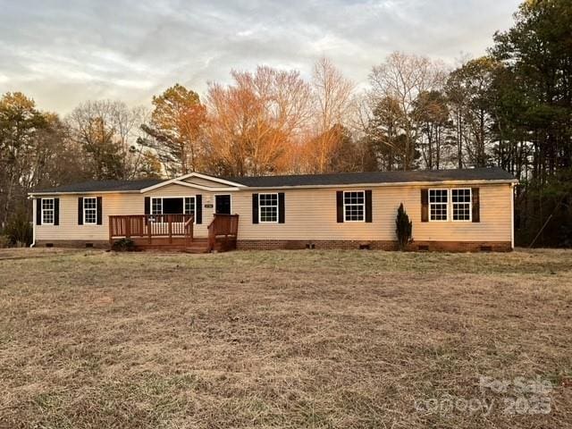 single story home featuring a front yard and a deck