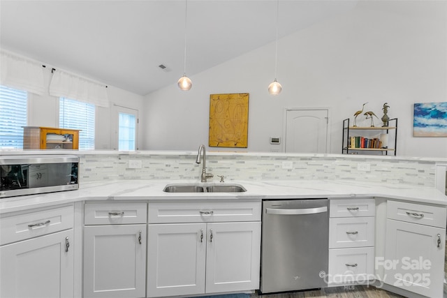 kitchen featuring white cabinetry, appliances with stainless steel finishes, sink, and decorative light fixtures