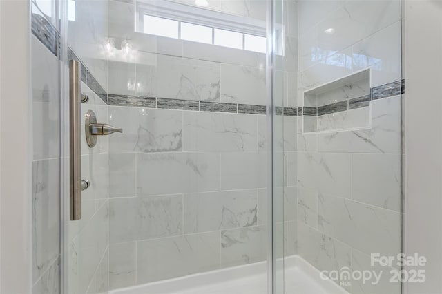 bathroom featuring a shower with door