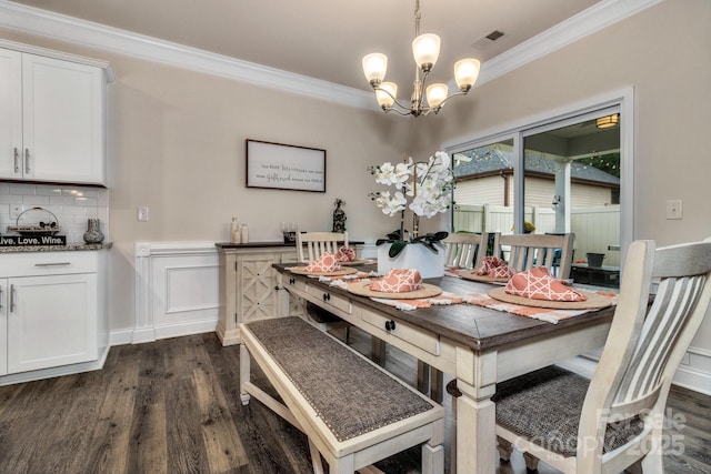 dining area featuring ornamental molding, dark hardwood / wood-style floors, and a chandelier