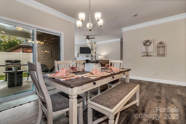 dining space featuring dark wood-type flooring, crown molding, and ceiling fan with notable chandelier