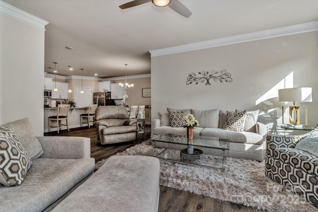 living room featuring dark hardwood / wood-style flooring, ceiling fan with notable chandelier, and crown molding