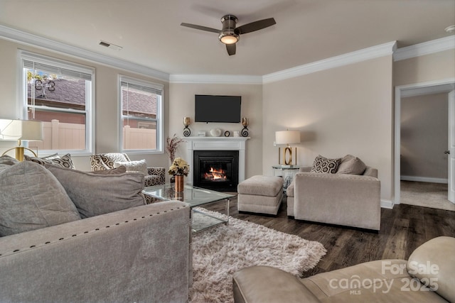 living room featuring dark wood-type flooring, ornamental molding, and a healthy amount of sunlight