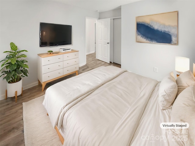 bedroom featuring light wood finished floors and baseboards