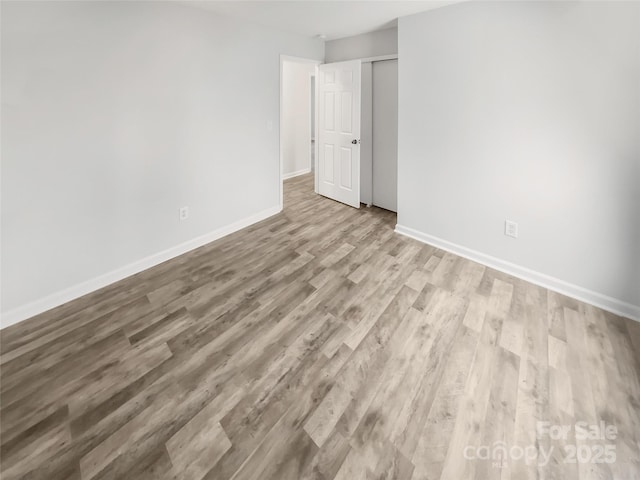 interior space with light wood finished floors, a closet, and baseboards