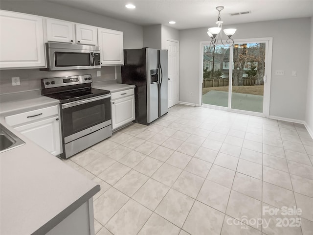 kitchen featuring white cabinetry, stainless steel appliances, and decorative light fixtures