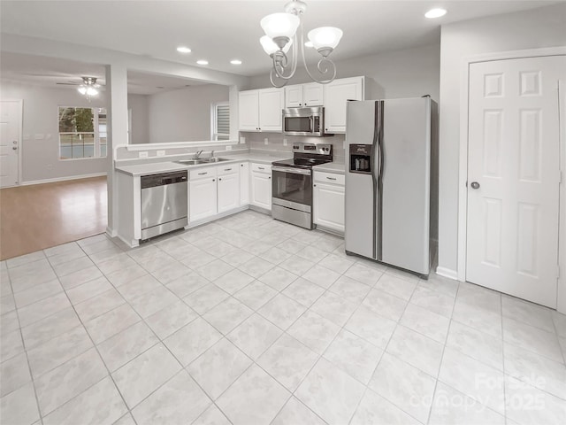 kitchen with recessed lighting, light countertops, appliances with stainless steel finishes, white cabinetry, and a sink