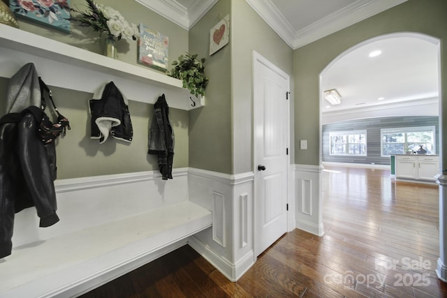 mudroom with arched walkways, ornamental molding, wainscoting, and hardwood / wood-style floors