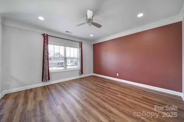 empty room featuring dark wood-style flooring, crown molding, recessed lighting, visible vents, and baseboards