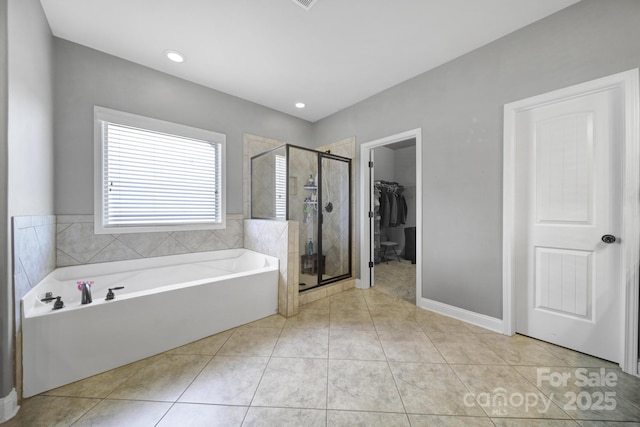 full bathroom with baseboards, a spacious closet, a bath, tile patterned floors, and a stall shower