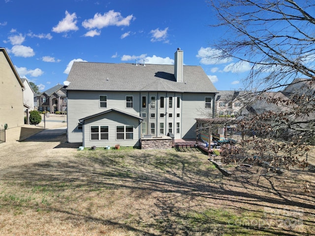 back of house with a shingled roof, a chimney, and a pergola