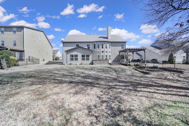 back of property with fence, a chimney, and a pergola