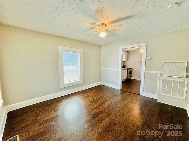 empty room featuring a textured ceiling, dark hardwood / wood-style floors, and ceiling fan