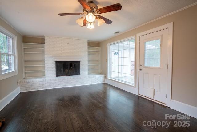 unfurnished living room featuring ornamental molding, a brick fireplace, dark wood-type flooring, and built in features