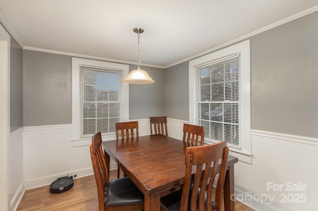 dining area with crown molding and hardwood / wood-style flooring