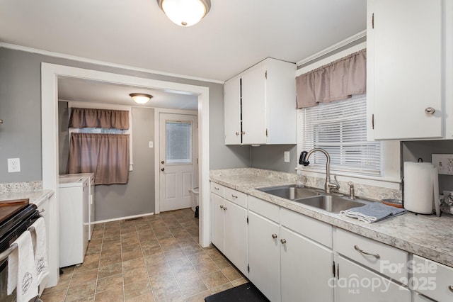 kitchen featuring washer / clothes dryer, white cabinetry, sink, stainless steel range with electric cooktop, and ornamental molding