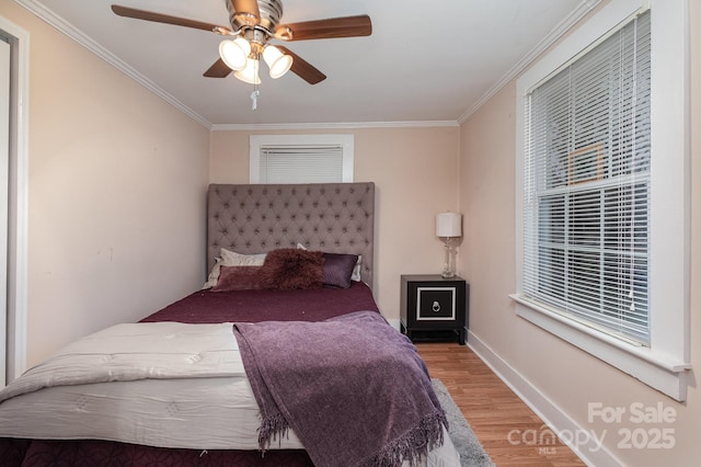 bedroom with hardwood / wood-style floors, crown molding, and ceiling fan