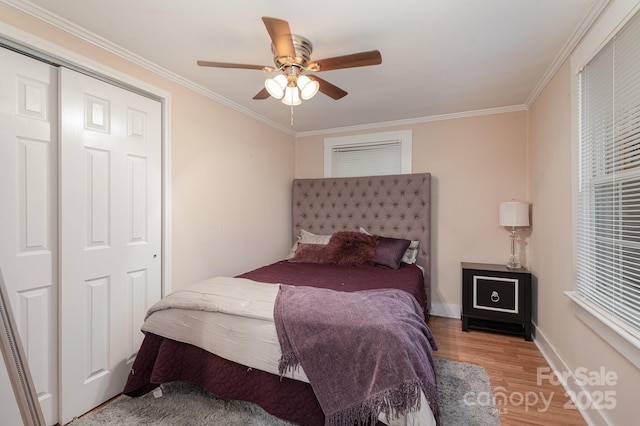 bedroom with wood-type flooring, ornamental molding, a closet, and ceiling fan