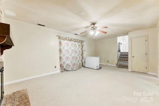 interior space featuring ceiling fan, refrigerator, carpet flooring, and a textured ceiling