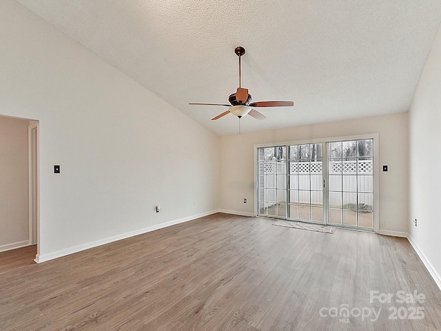 unfurnished room featuring ceiling fan, a textured ceiling, baseboards, vaulted ceiling, and light wood-type flooring