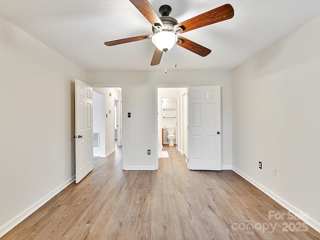 unfurnished bedroom with visible vents, light wood-style flooring, baseboards, and a textured ceiling